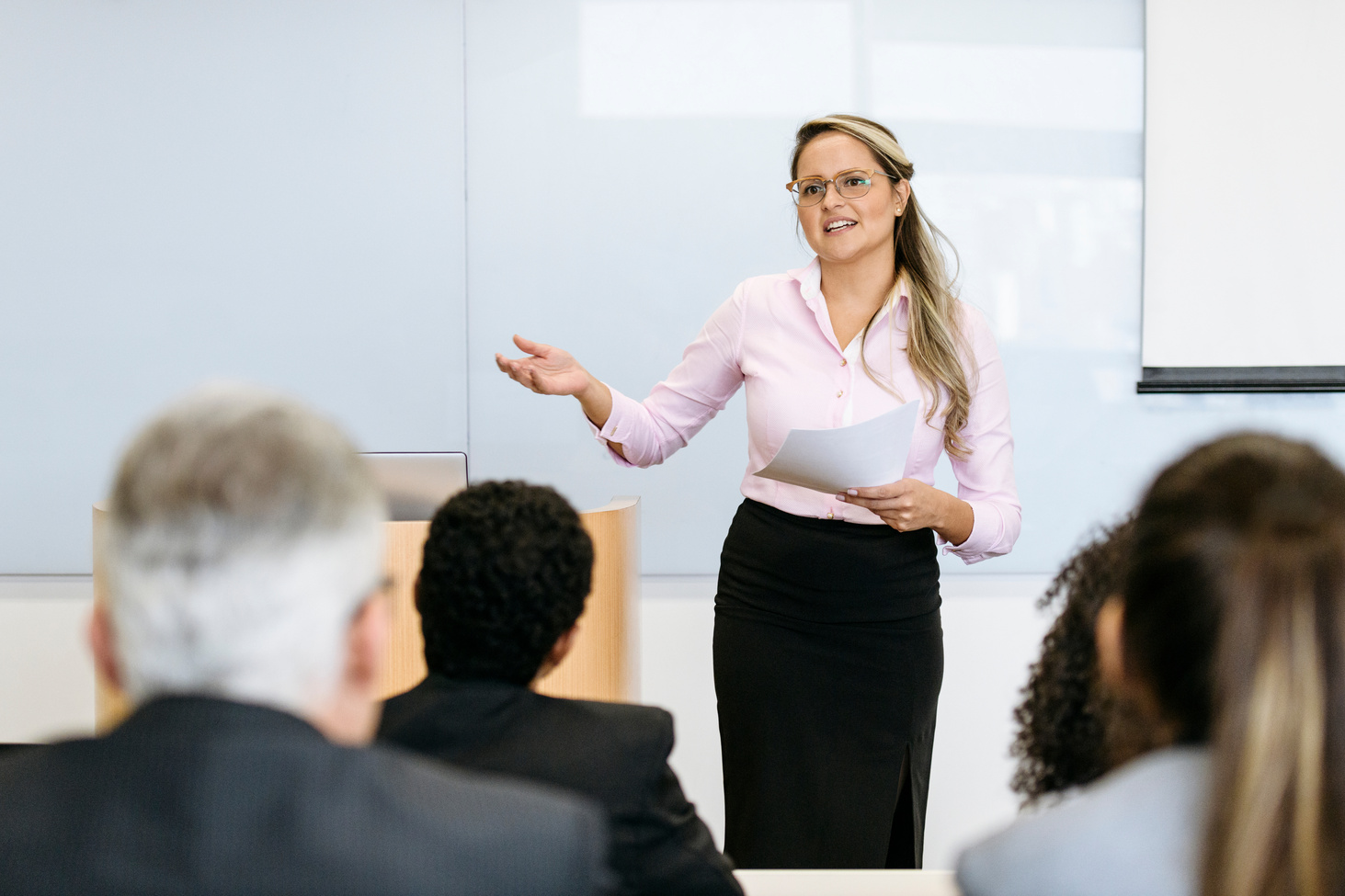 Confident mid adult businesswoman speaking to audience